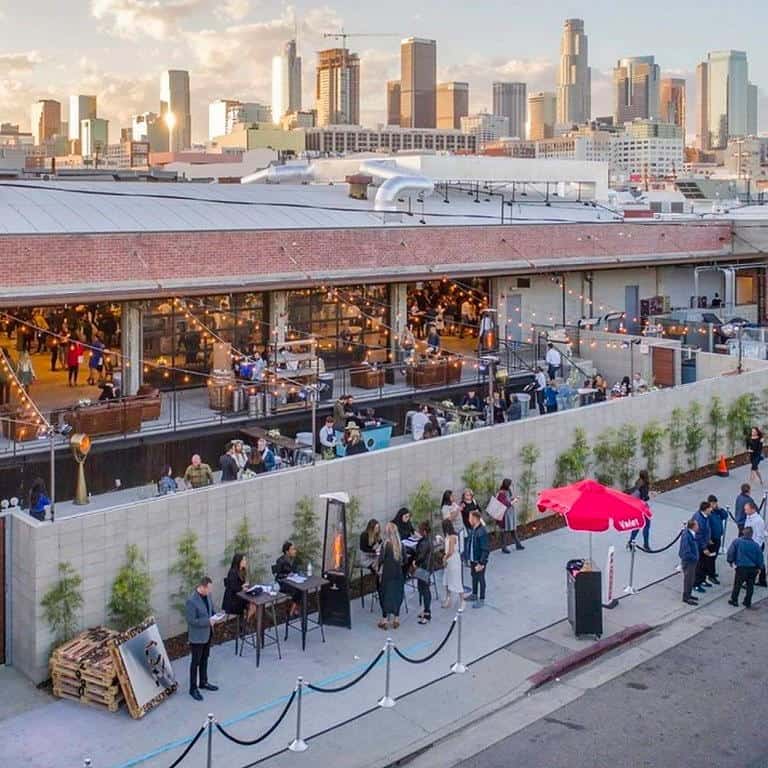 exterior view of a vibrant City Market Social House with downtown LA in the background