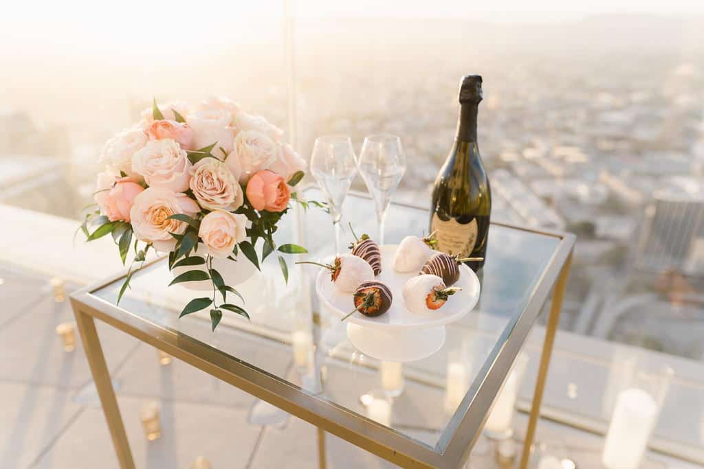 bouqet of flowers, wine glasses and a bottle of wine on a table
